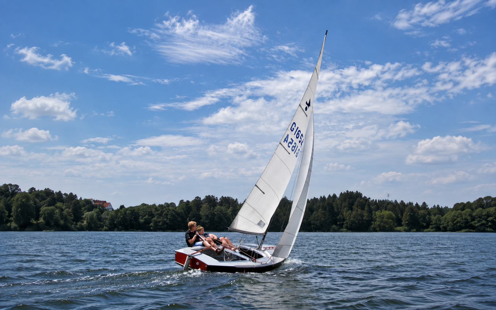 Zwei Segler auf einer vollständig sichtbaren Jolle mit Segeln; Vereinsfoto seitlich mit KI erweitert